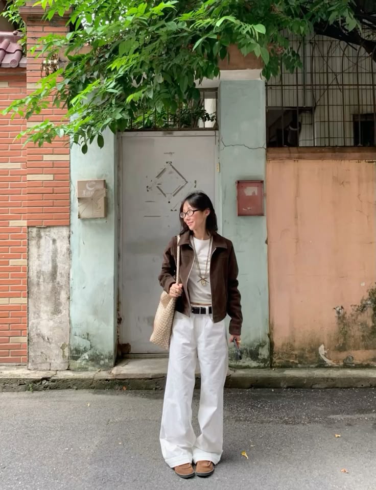 Outfit featuring a brown jacket, a white t-shirt, and white wide leg pants, styled with a belt and accessories.
