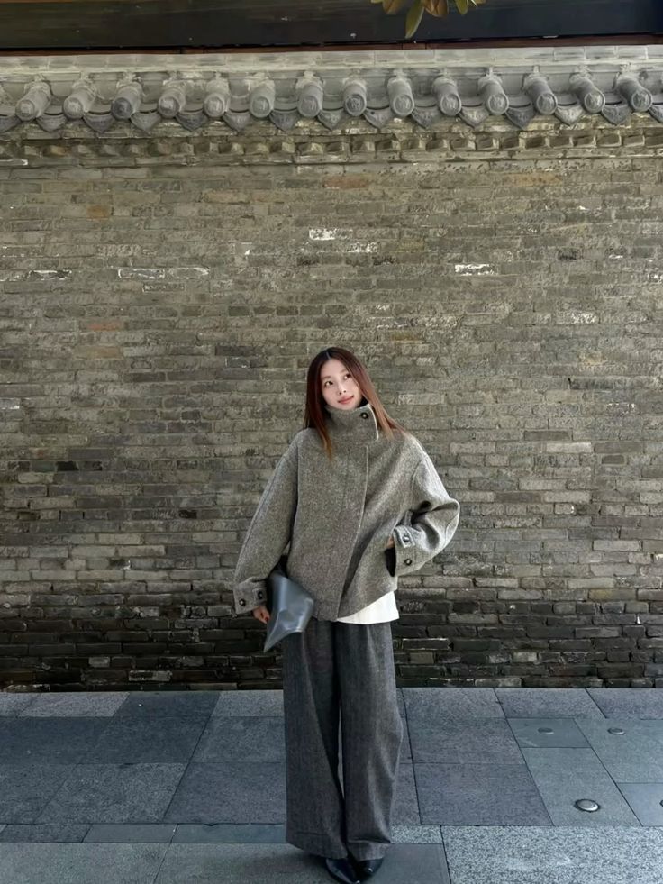 The outfit features a boxy knit jacket in gray paired with wide leg trousers in a matching check pattern.
