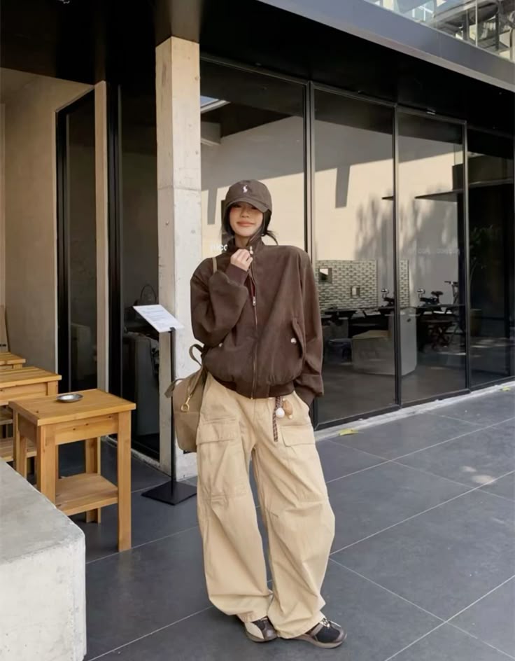A brown hooded zip-up jacket paired with beige baggy cargo pants and casual footwear.