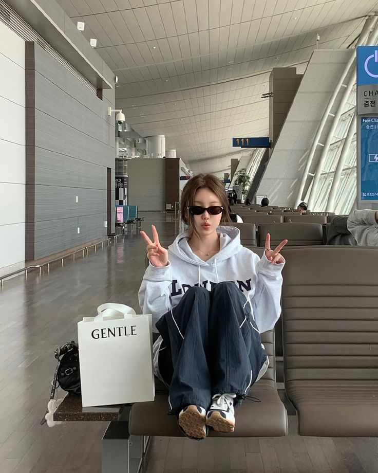 A casual outfit featuring a gray hoodie, baggy navy trousers, and sunglasses.